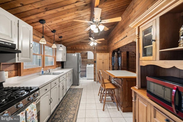 kitchen featuring appliances with stainless steel finishes, washer / clothes dryer, wooden ceiling, and a sink