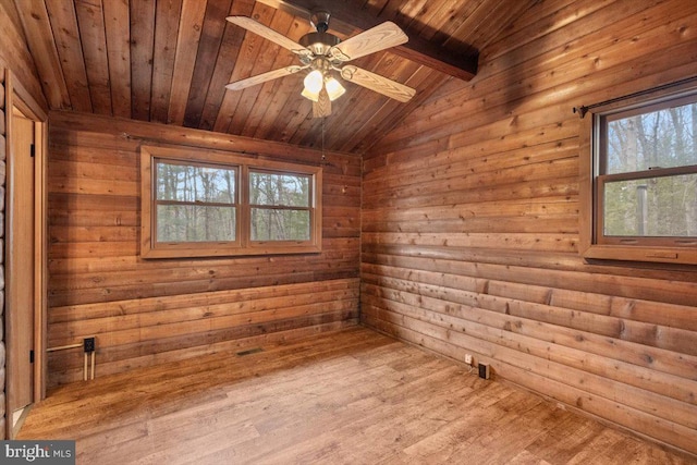 empty room with a wealth of natural light, wooden ceiling, lofted ceiling with beams, and wood finished floors