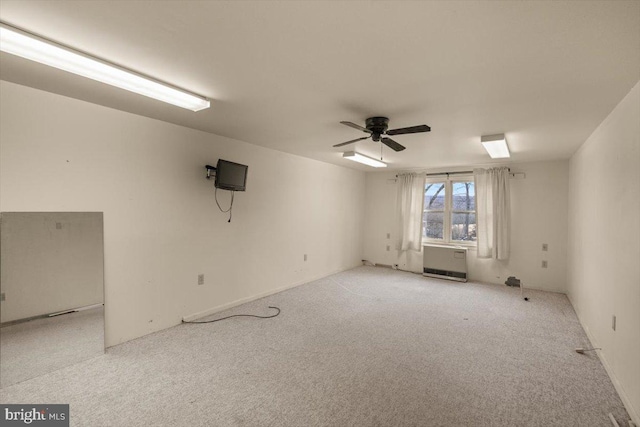 empty room featuring ceiling fan, carpet, and heating unit