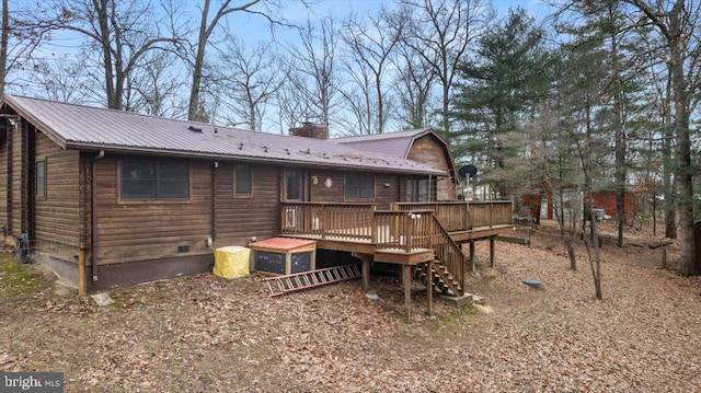 back of house featuring stairway, metal roof, a chimney, and a wooden deck