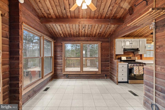 kitchen with under cabinet range hood, light tile patterned floors, visible vents, and stainless steel range with gas stovetop