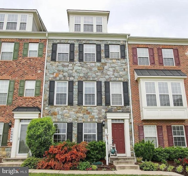 townhome / multi-family property featuring stone siding and brick siding