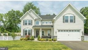 view of front facade with an attached garage, a porch, aphalt driveway, and a front yard