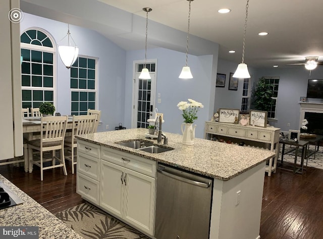 kitchen with dark wood-style floors, light stone counters, white cabinets, a sink, and dishwasher