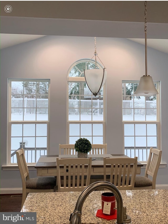 dining room featuring lofted ceiling and baseboards