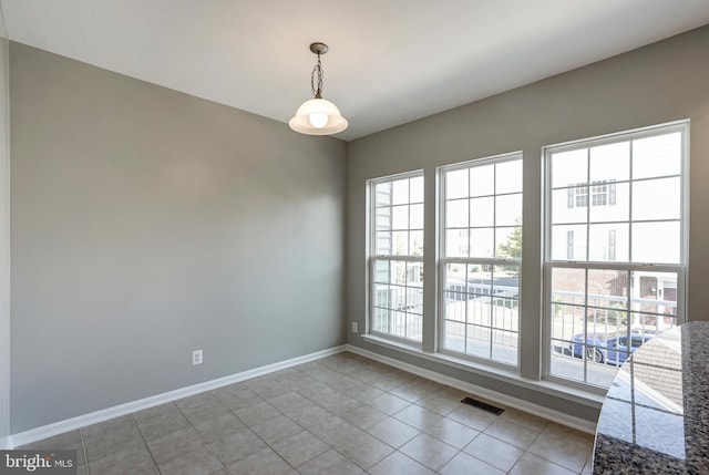 empty room with light tile patterned floors, baseboards, and visible vents