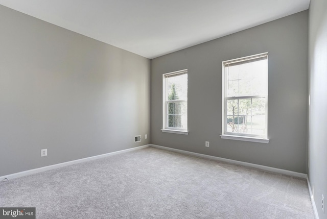 spare room with light carpet and baseboards