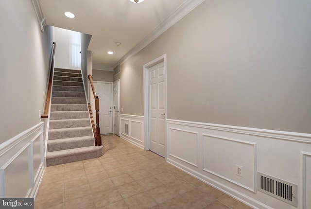 hallway featuring stairs, visible vents, crown molding, and light tile patterned floors