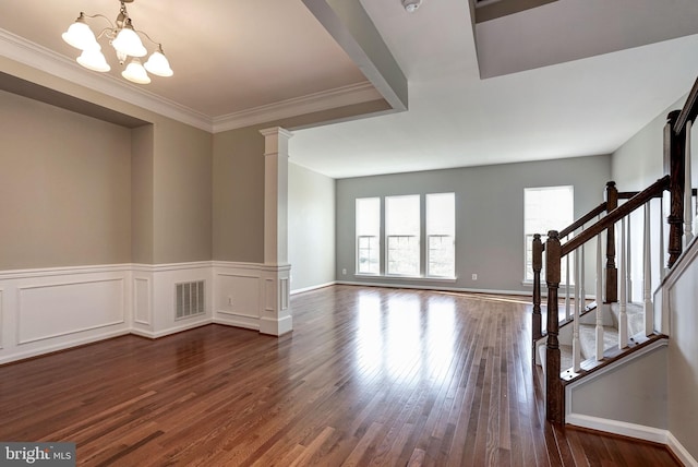 interior space with a notable chandelier, dark wood-style flooring, visible vents, stairway, and decorative columns