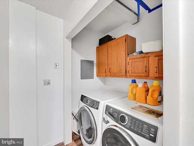 clothes washing area with cabinet space, electric panel, and washer and dryer