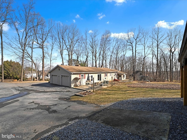 view of front of house with aphalt driveway, a front yard, and an attached garage