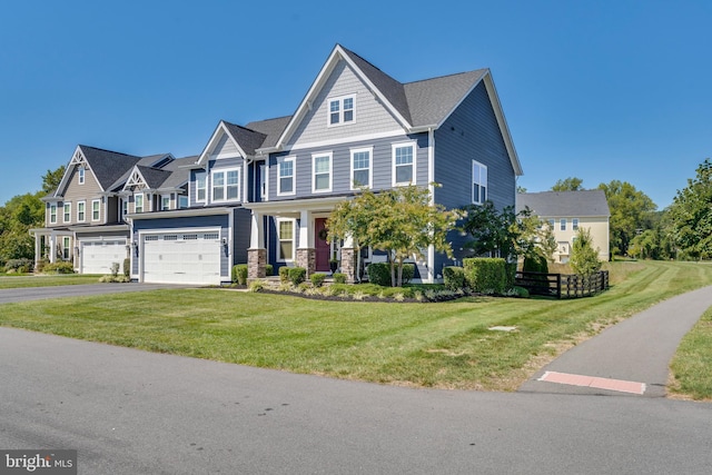 view of front of home featuring aphalt driveway, an attached garage, a front yard, a residential view, and stone siding