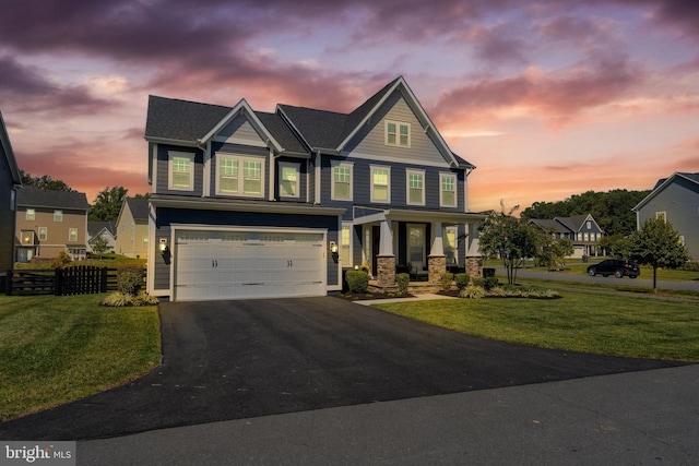 craftsman house featuring aphalt driveway, a yard, an attached garage, and fence