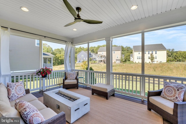 sunroom with a ceiling fan, a residential view, and wooden ceiling