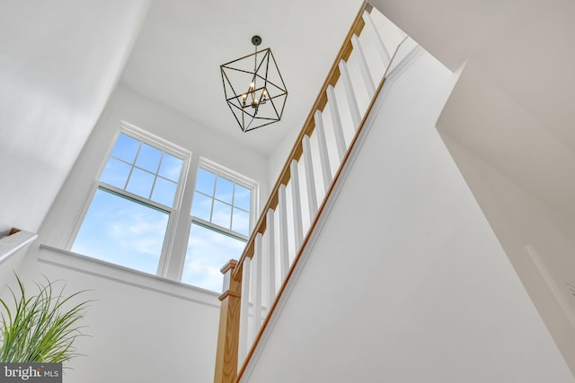 staircase with a chandelier