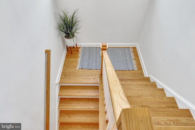 staircase with wood finished floors and baseboards