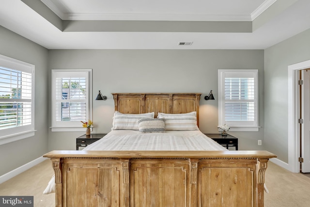 bedroom featuring a tray ceiling, light carpet, and baseboards