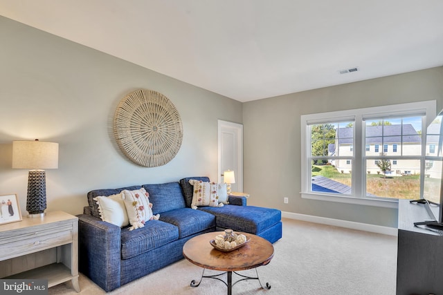 living room with light carpet, visible vents, and baseboards