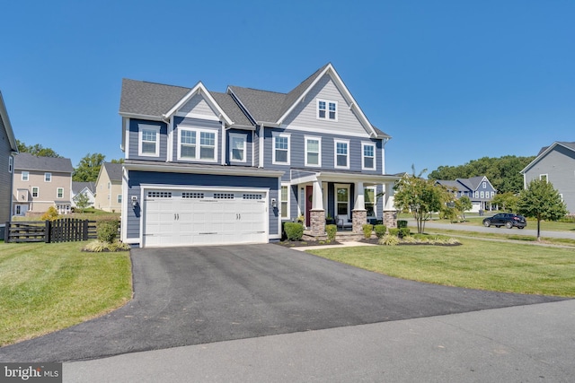 craftsman-style home featuring an attached garage, fence, driveway, a residential view, and a front lawn