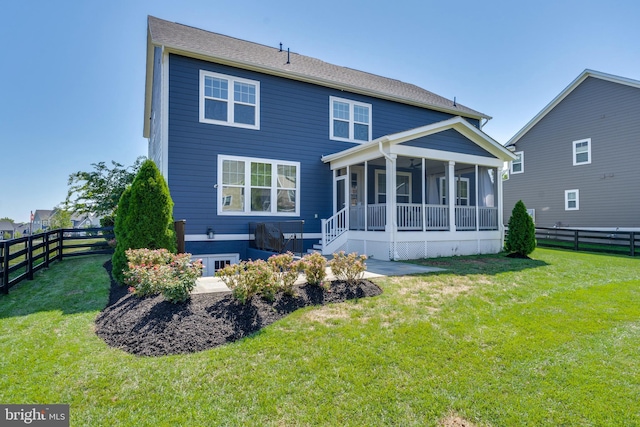 back of property with a lawn, a fenced backyard, and a sunroom