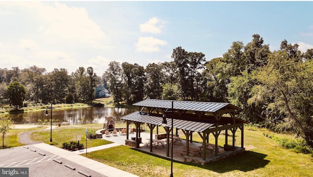 view of property's community with a yard, a patio, a water view, and a gazebo