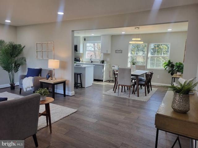 living room with dark wood-type flooring, recessed lighting, and baseboards