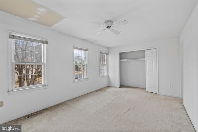 unfurnished bedroom with carpet, a closet, visible vents, ceiling fan, and baseboards