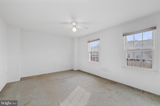 unfurnished room with ceiling fan, carpet floors, and visible vents