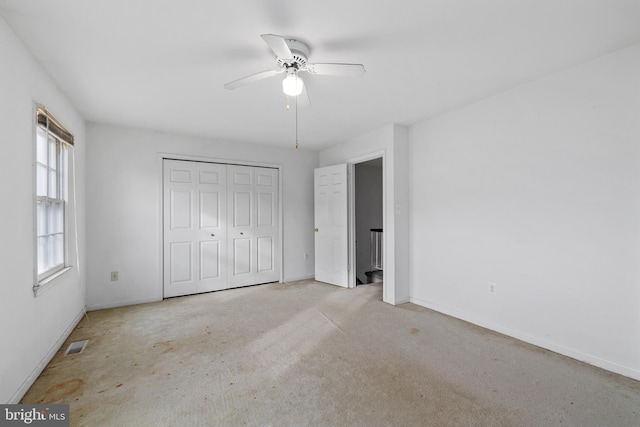 unfurnished bedroom with carpet floors, a closet, visible vents, and baseboards