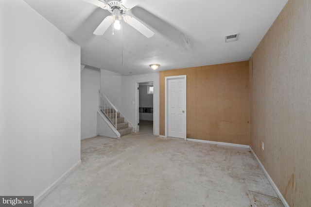 interior space featuring baseboards, stairway, visible vents, and a ceiling fan