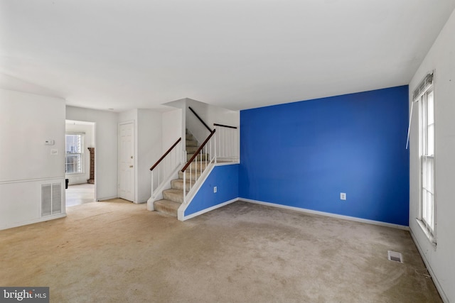 interior space with carpet, visible vents, stairway, and baseboards