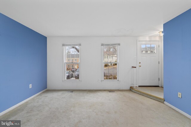 carpeted empty room featuring visible vents and baseboards