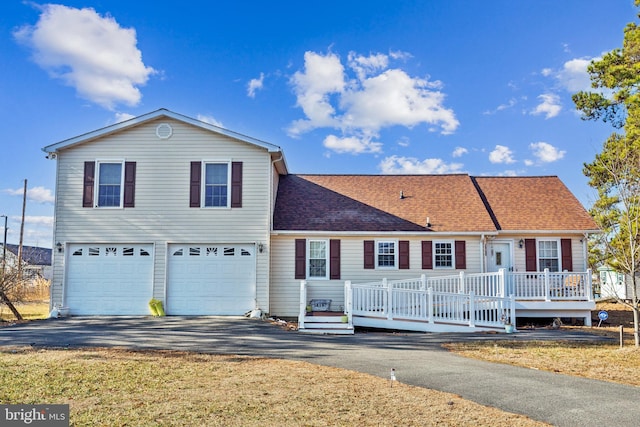 view of front of house featuring a garage, driveway, and a shingled roof