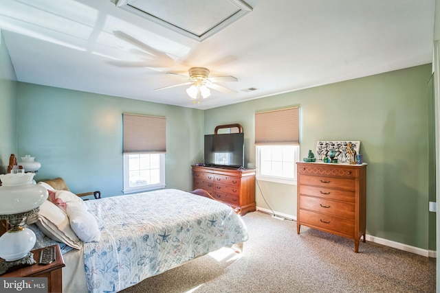 bedroom with a ceiling fan, baseboards, visible vents, attic access, and carpet flooring