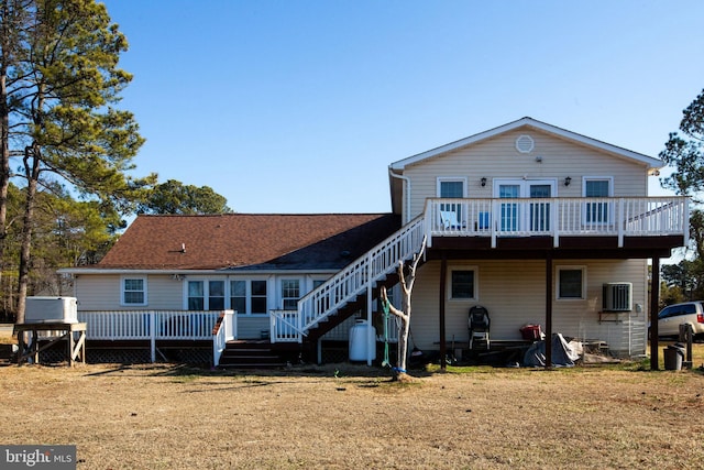 back of property with a shingled roof and a deck