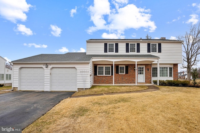 view of front facade featuring brick siding, a porch, a front yard, a garage, and driveway