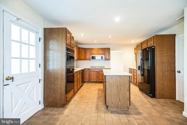 kitchen featuring a center island, tasteful backsplash, light countertops, brown cabinetry, and black appliances