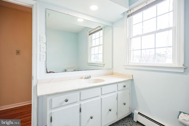 bathroom with recessed lighting, baseboards, a baseboard heating unit, and vanity