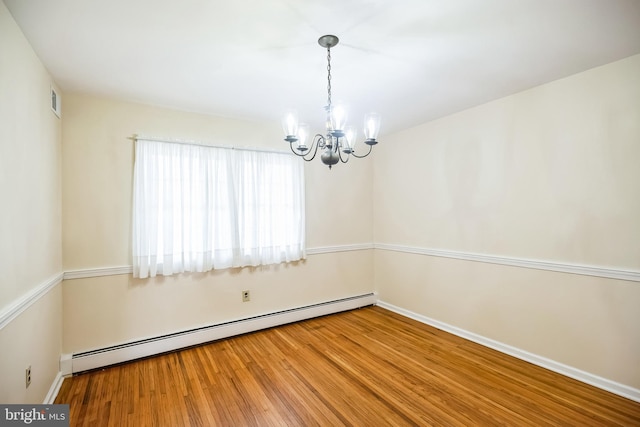 empty room with baseboards, visible vents, a chandelier, wood finished floors, and a baseboard heating unit