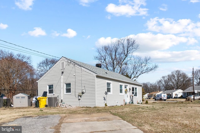 view of home's exterior with roof with shingles, a chimney, and a lawn