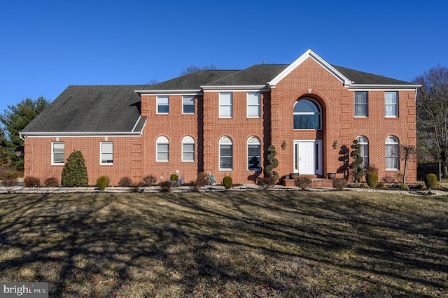 view of front of property featuring a front lawn and brick siding