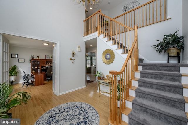 foyer entrance with baseboards, stairway, and wood finished floors