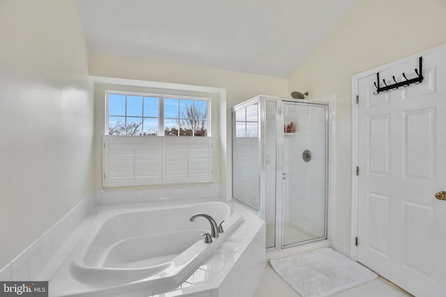 full bathroom with lofted ceiling, a garden tub, and a shower stall