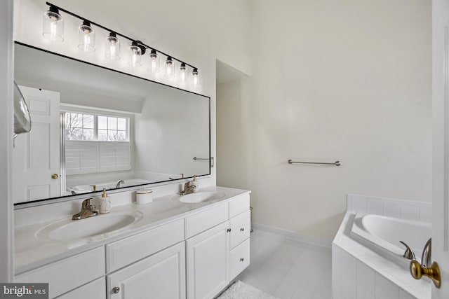 full bathroom featuring a garden tub, a sink, baseboards, and double vanity