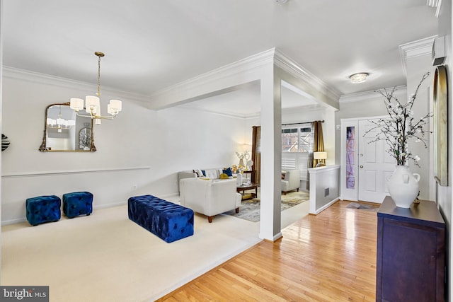 entryway with light wood-type flooring, a notable chandelier, crown molding, and baseboards