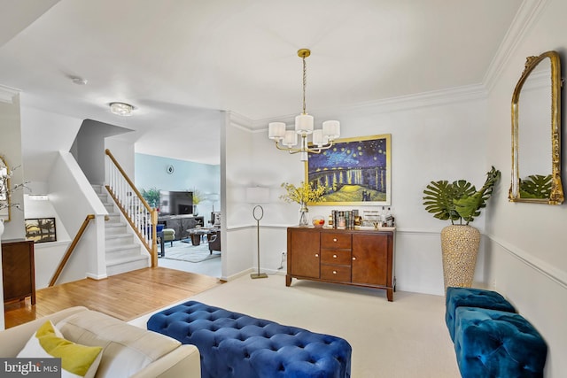 living room with carpet floors, stairs, ornamental molding, and a notable chandelier