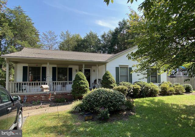 ranch-style house featuring a porch and a front yard