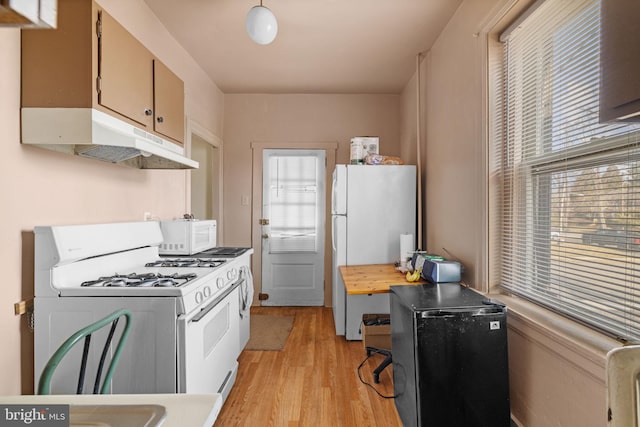 kitchen with light wood-style floors, white appliances, light countertops, and under cabinet range hood