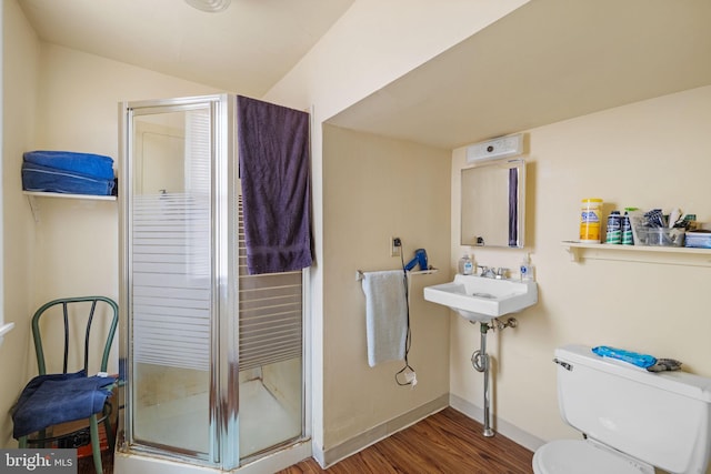 full bathroom featuring a stall shower, wood finished floors, toilet, and baseboards