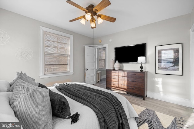 bedroom featuring wood finished floors, a ceiling fan, and baseboards